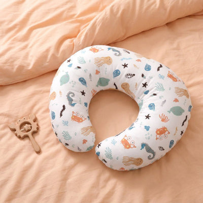 Coussin d'allaitement sur des draps de lit