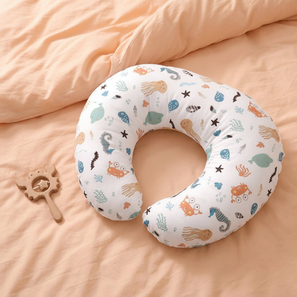 Coussin d'allaitement sur des draps de lit