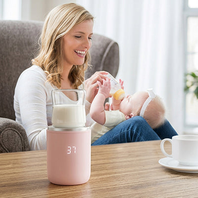 Chauffe biberon nomade rose avec maman biberon bébé sur fauteuil