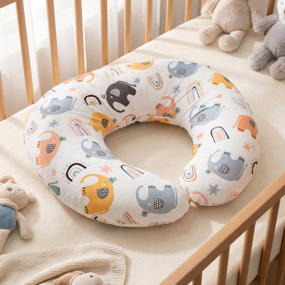 Coussin d'allaitement posé sur un lit de bébé