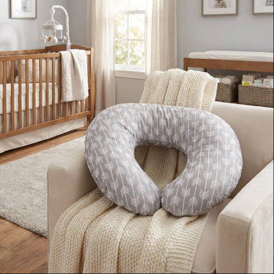 Coussin d'allaitement sur un fauteuil dans la chambre de bébé