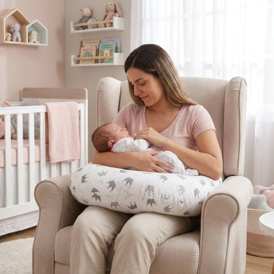 Maman et bébé avec coussin d'allaitement sur un fauteuil