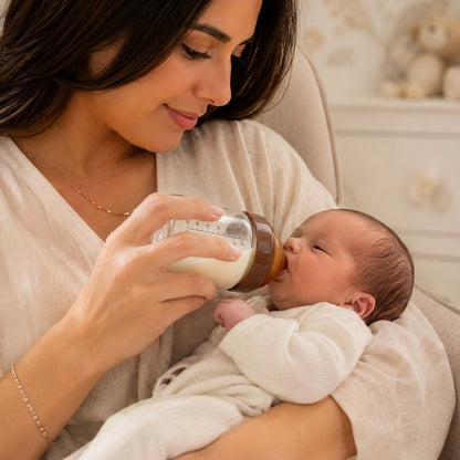 Maman donne le biberon en verre à bébé nouveau-né