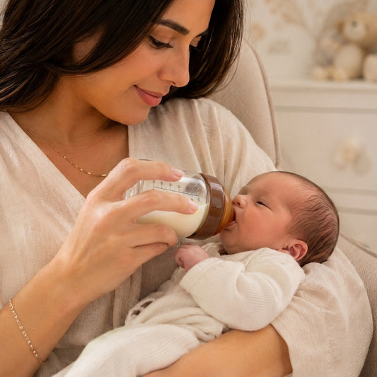 Maman donne le biberon en verre à bébé nouveau-né