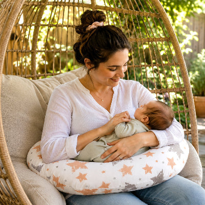 Maman tient bébé sur le coussin d'allaitement dans jardin