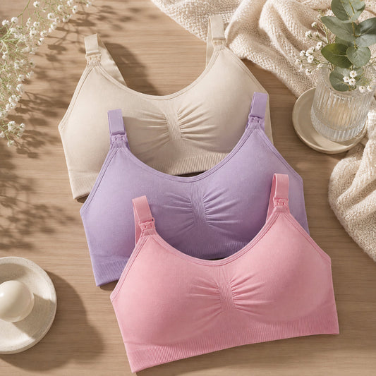 Soutien-gorges d'allaitement rose violet beige posés sur table